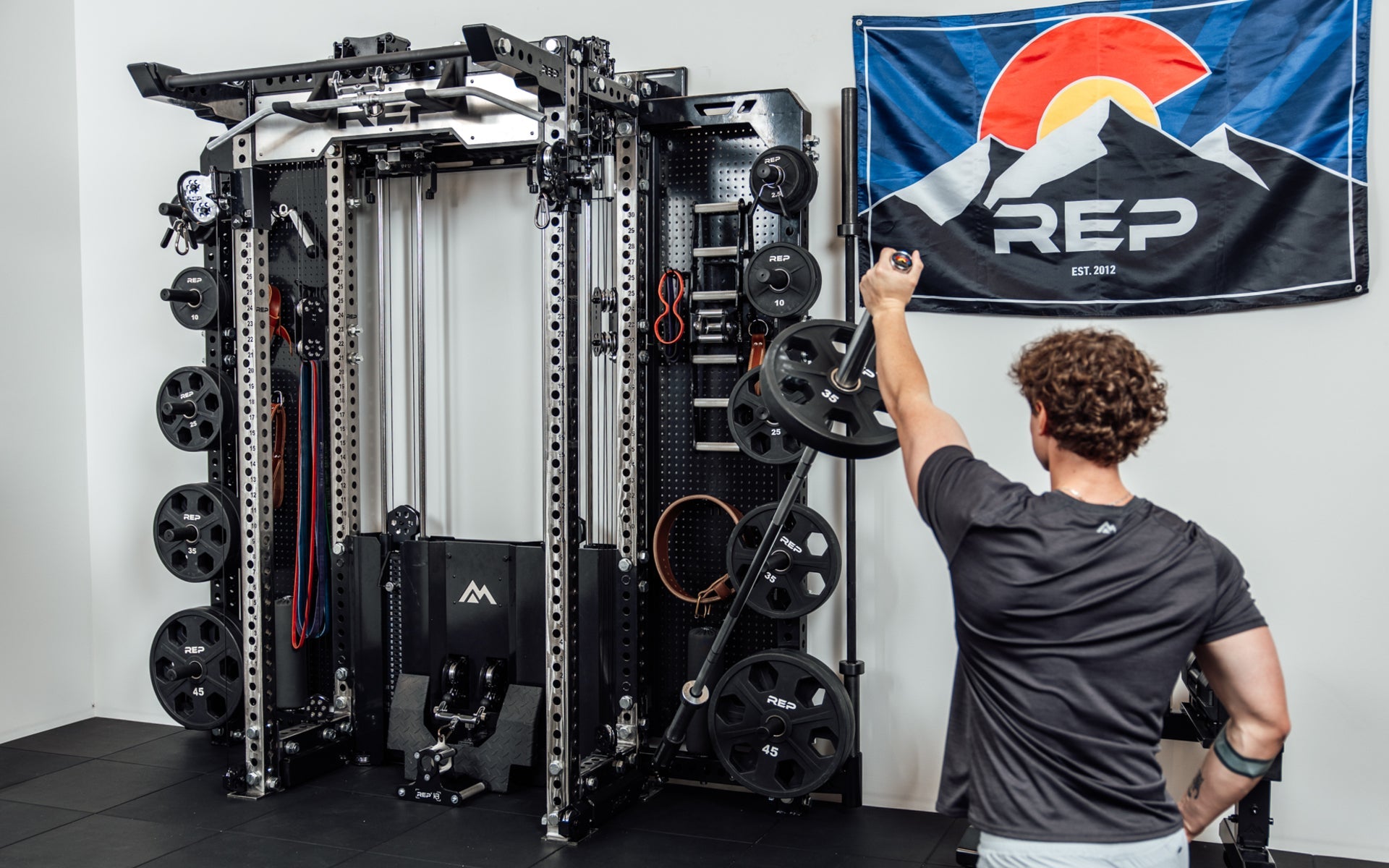 An athlete using the Rack Mounted REP® x Kleva Built® Adroit Landmine to do presses on the Wall-Mounted Ares™ 2.0