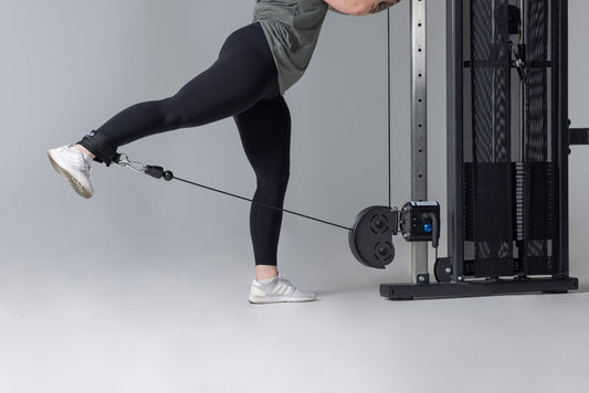 Athlete does a kickback on a cable machine.