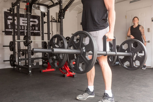 Athlete uses REP® Farmer's Handles to tackle a farmer carry workout.