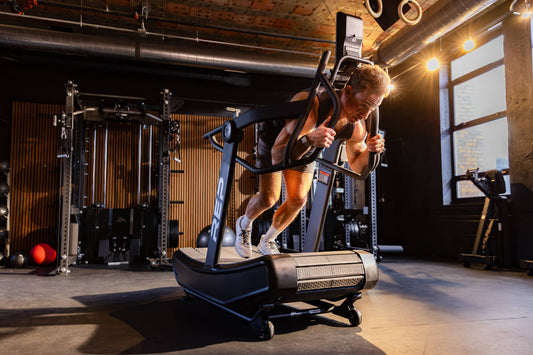 Athlete does a sled push on the Strive™ Curved Treadmill.