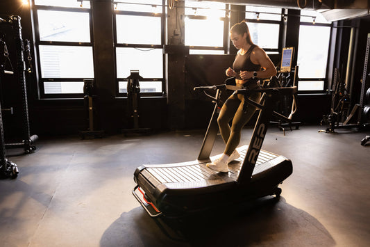 Athlete walks backwards on the Strive™ Curved Treadmill.