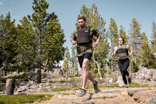Two athletes run with the Strata™ Weight Vest.